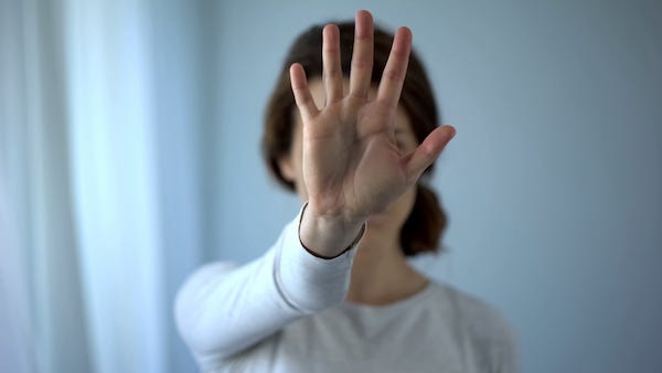 Woman holding up hand in rejection