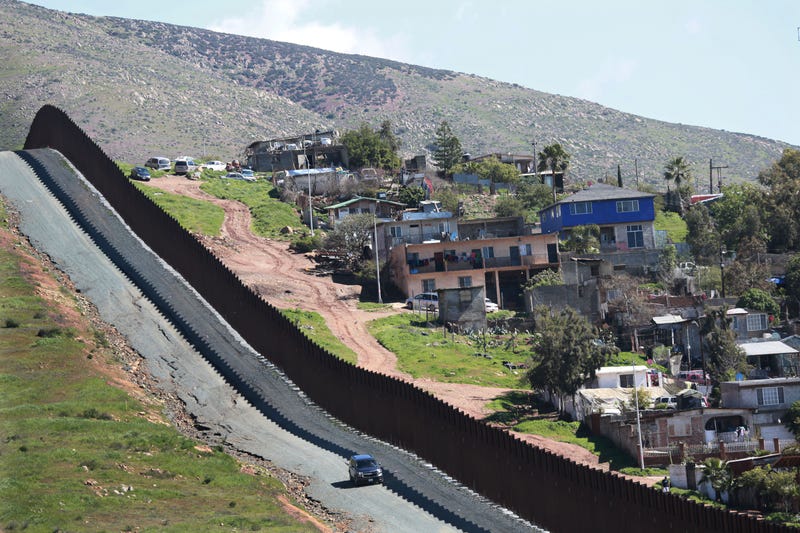 A car drives along the U.S.-Mexico border fence on February 22, 2019 in Otay Mesa, California.