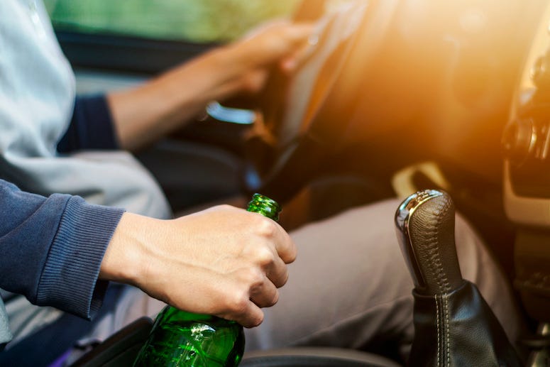 Man drinking alcohol while driving