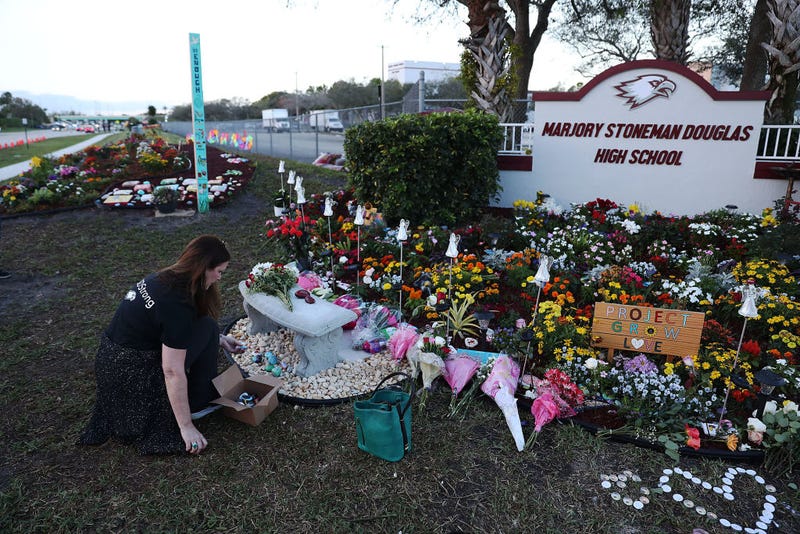 Suzanne Devine Clark visits a memorial setup at Marjory Stoneman Douglas High School for those killed during a mass shooting on February 14, 2019 in Parkland, Florida.