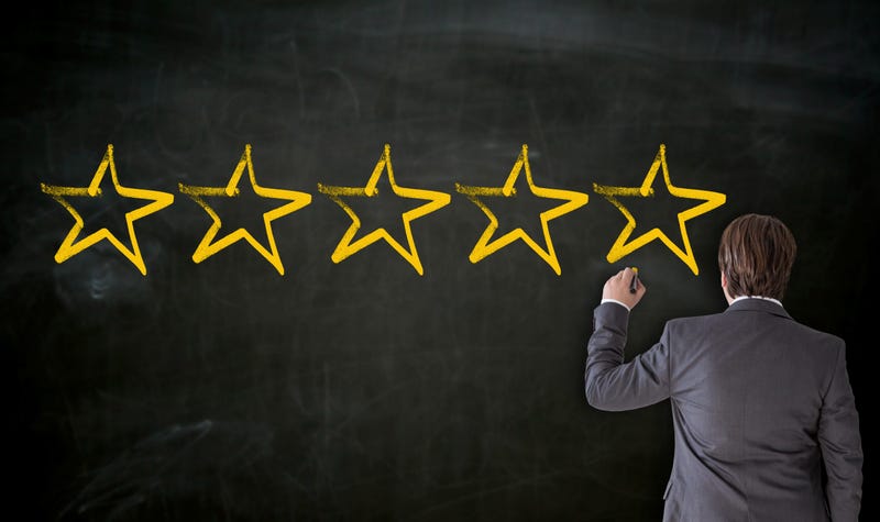 Teacher putting stars on a chalkboard. 