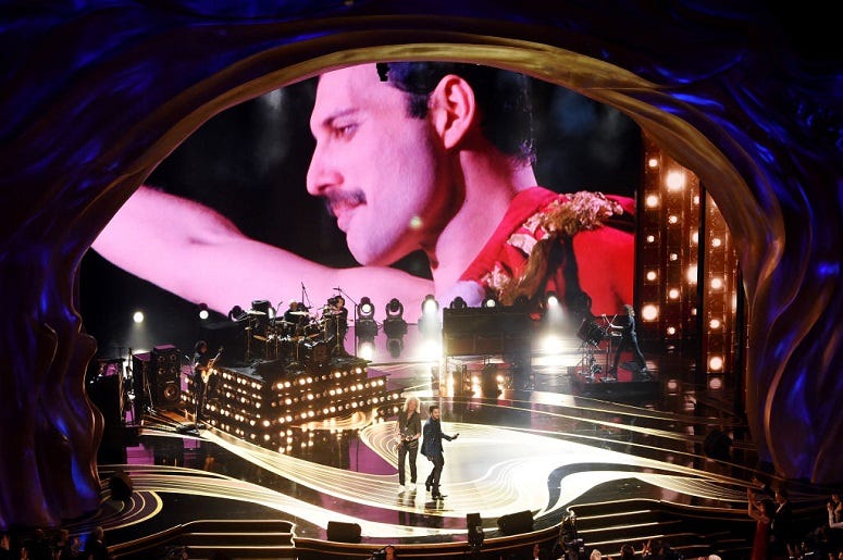An image of the late Freddie Mercury is projected onto a screen while Adam Lambert + Queen perform onstage during the 91st Annual Academy Awards
