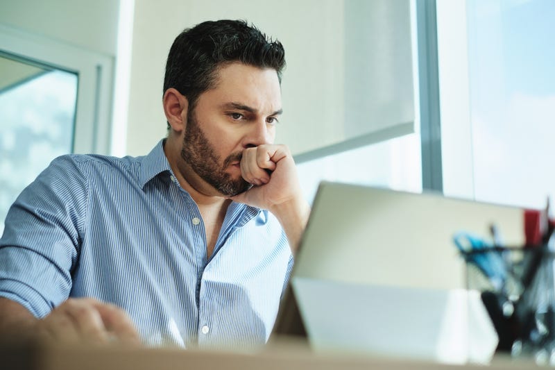 Confused man looks at computer