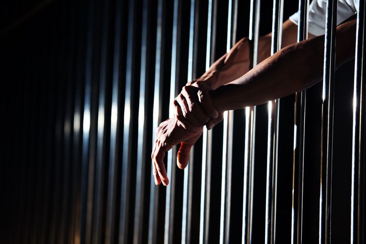 Close up of hand in jail background.