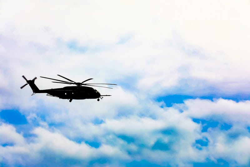 helicopter flying over the ocean
