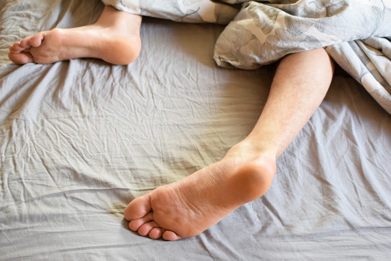 Man's feet sleeping on bed