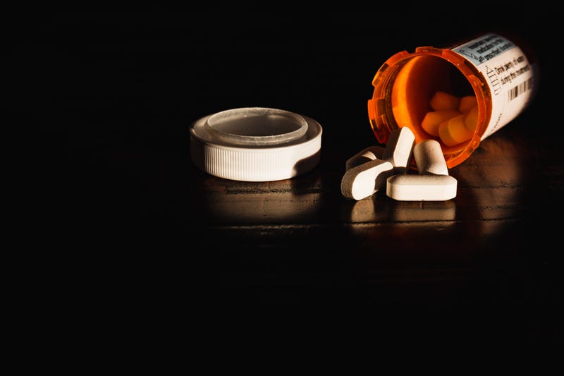 A bottle of prescription pills against a dark background
