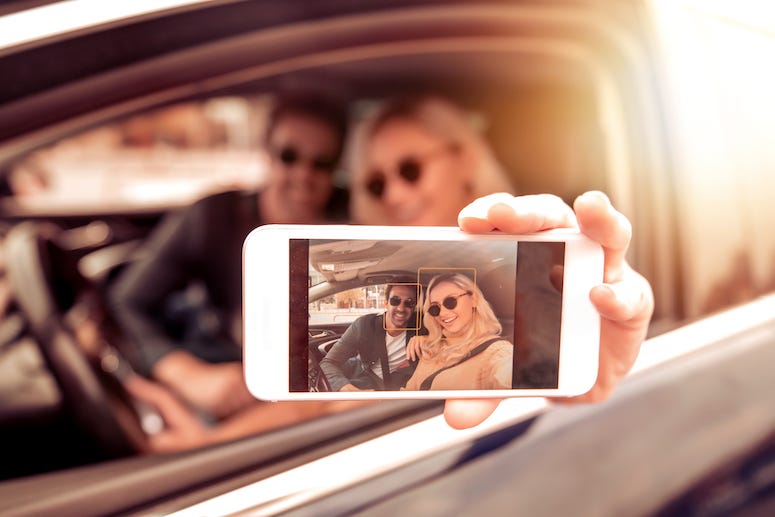 Couple taking selfie in car