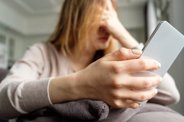 Upset woman holding smart phone