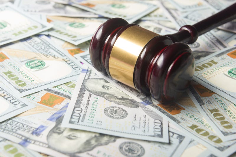 Gavel on money depicting a legal settlement. 