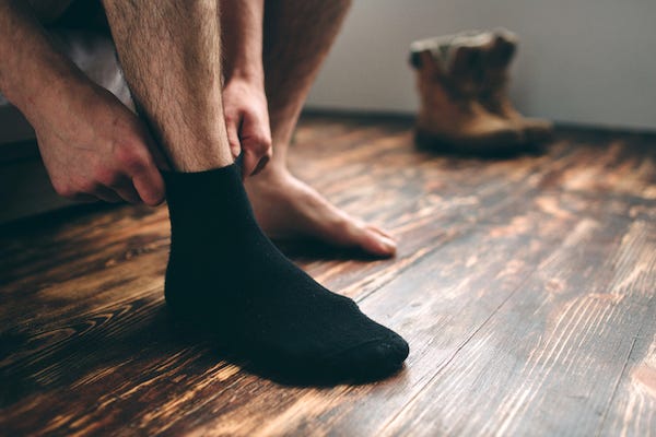 Man putting on black socks