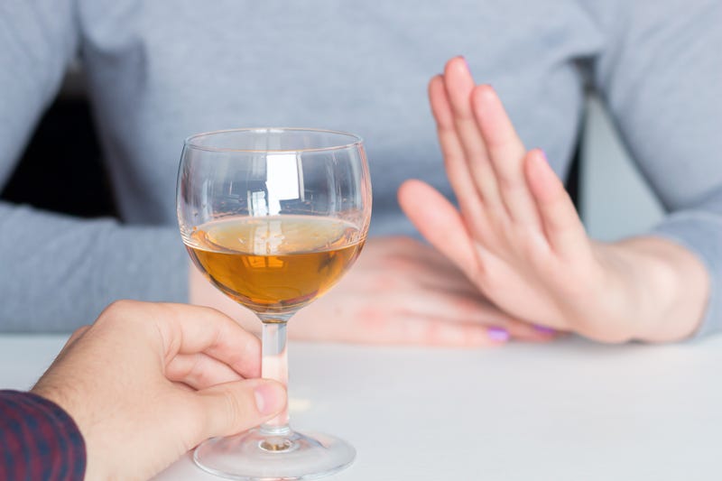 A woman says no to an alcoholic drink.
