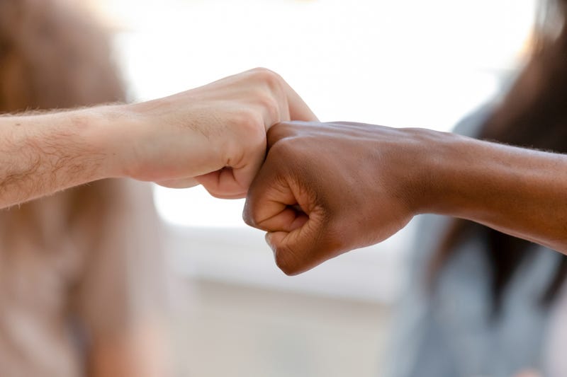 Diverse male hands giving fist bump, two african american and caucasian men greeting as business partnership, multiracial people friends culture, power trust respect support