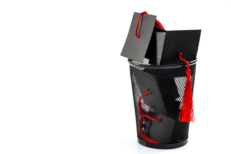 College graduation caps in a trash can.