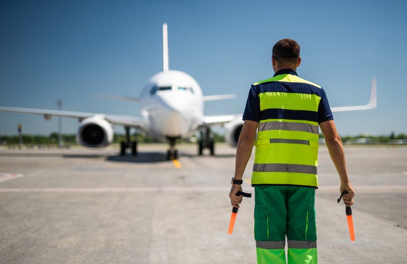 airport worker meeting passenger aircraft