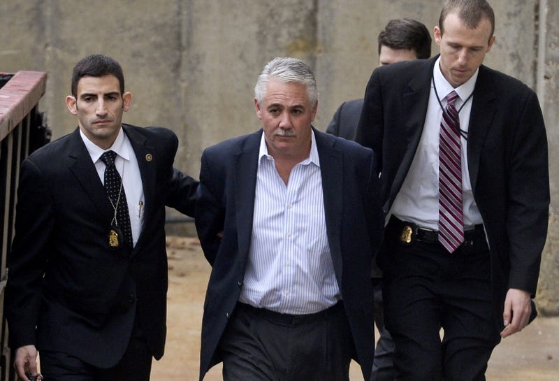 James Burke is escorted to a vehicle by FBI personnel outside the FBI office in Melville on Dec. 9, 2015