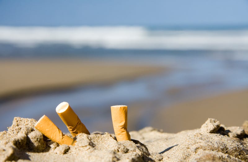 Three cigarettes on a beach.