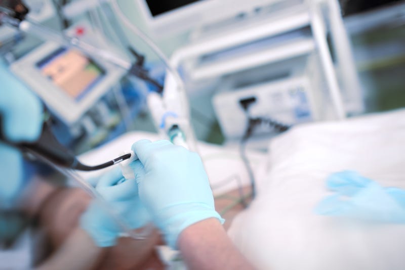 nurse works with IV in hospital room