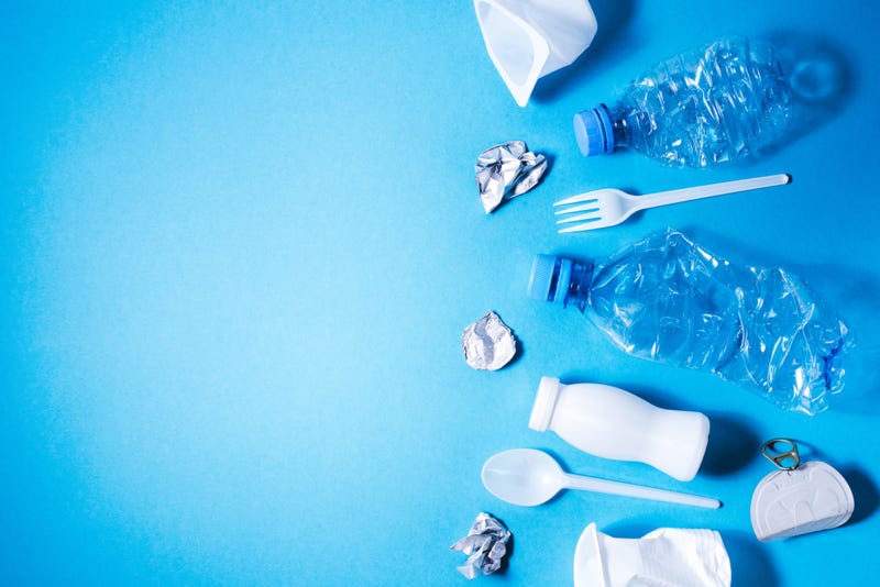 Plastic trash on blue background, eco concept image with copy space.