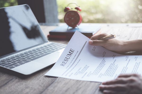 Man reviews his résumé at his desk