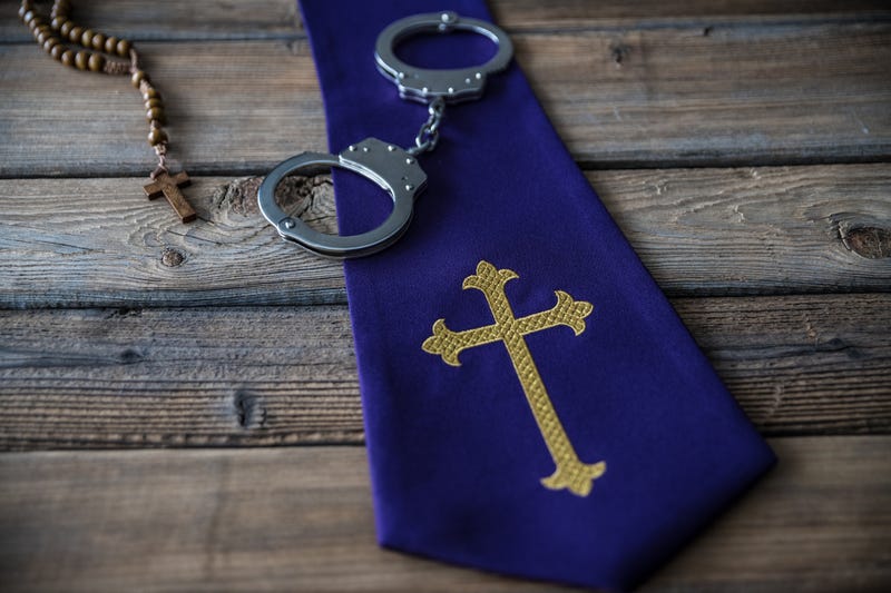 Handcuffs and catholic church symbols. Church and crime