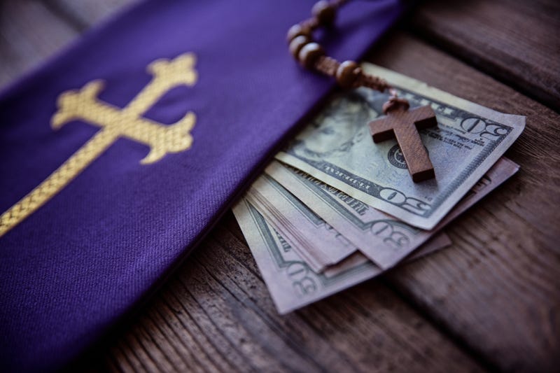 Wooden rosary and catholic church symbols and money. Church and money