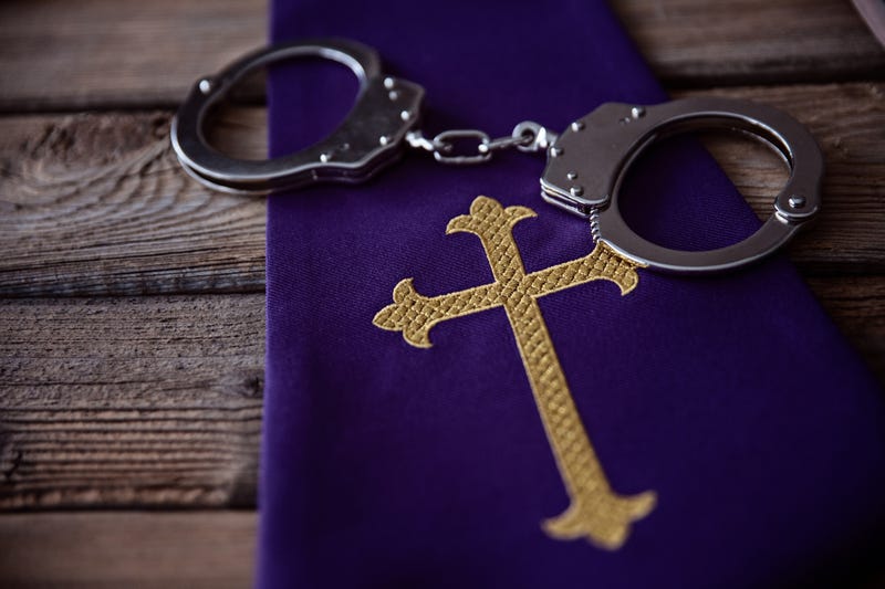 Catholic church symbols and handcuffs. Church and crime