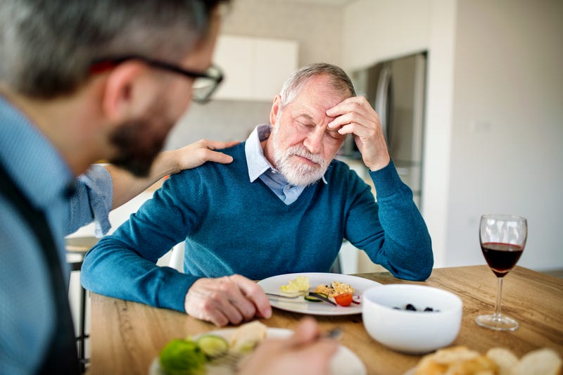 man and son fighting at dinner table