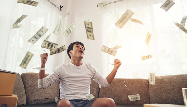 Happy man with cash flying around his home