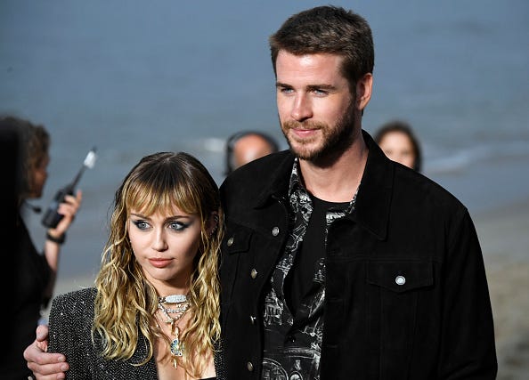 Exes Miley Cyrus and Liam Hemsworth pose for photos. 