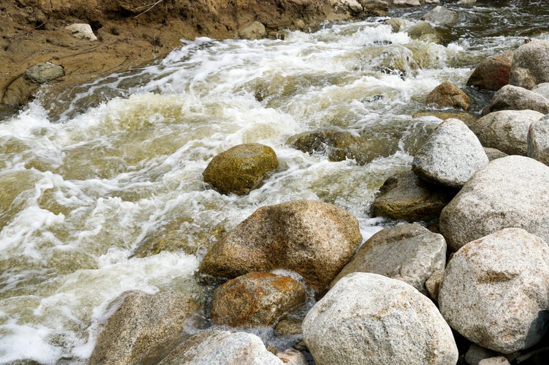 Close up fast flowing water between rocks in the mountain river,