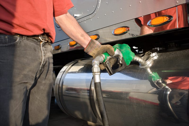 Truck driver fueling his vehicle with diesel fuel.