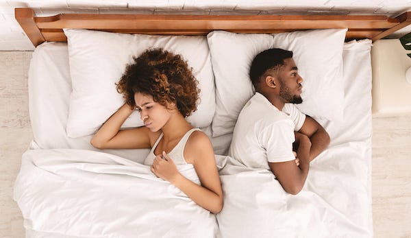 Angry couple ignoring each other in bed