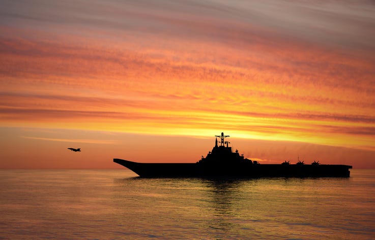 Aircraft carrier at sunset. 