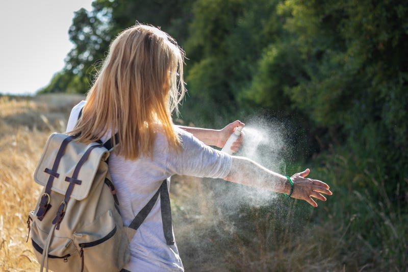 Woman using mosquito spray
