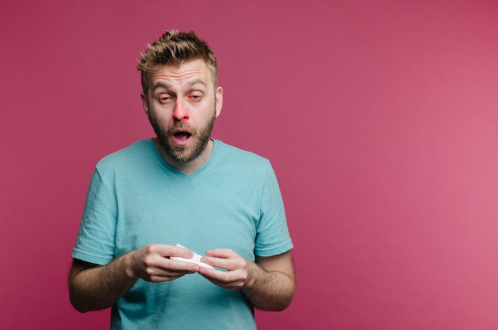 Person sneezing with itchy eyes.