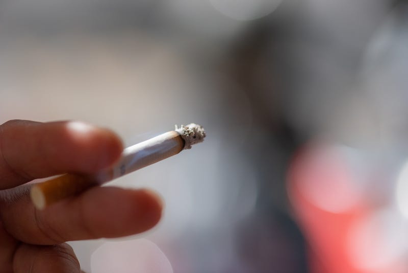 Hand holding lit cigarette stock photo. 