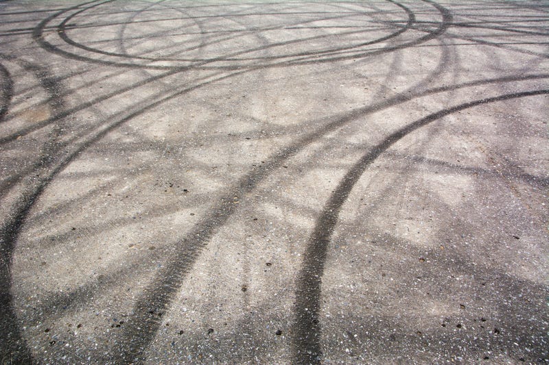 Traces of braking from rubber tyres on cement, black tire track skid mark