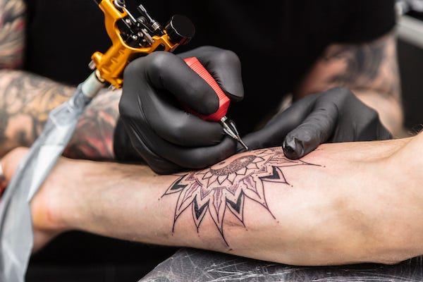Tattoo artist working on a client