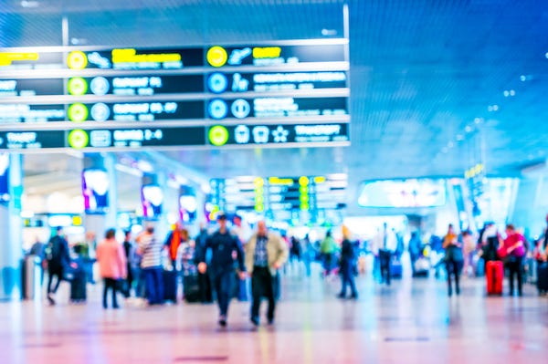 Blurry image of passengers walking through airport terminal