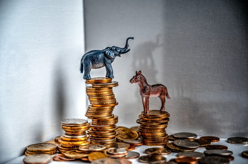 donkey and elephant on top of stacks of coins