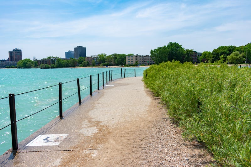 A path with native plants and Lake Michigan leading to a beach in Rogers Park