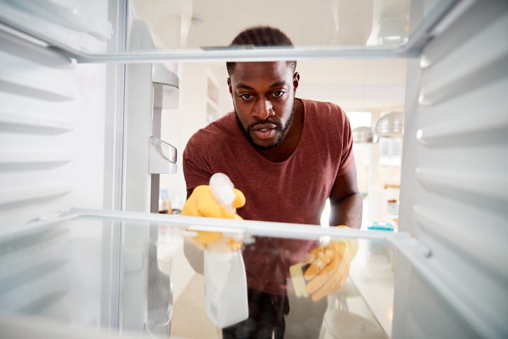 man cleans fridge