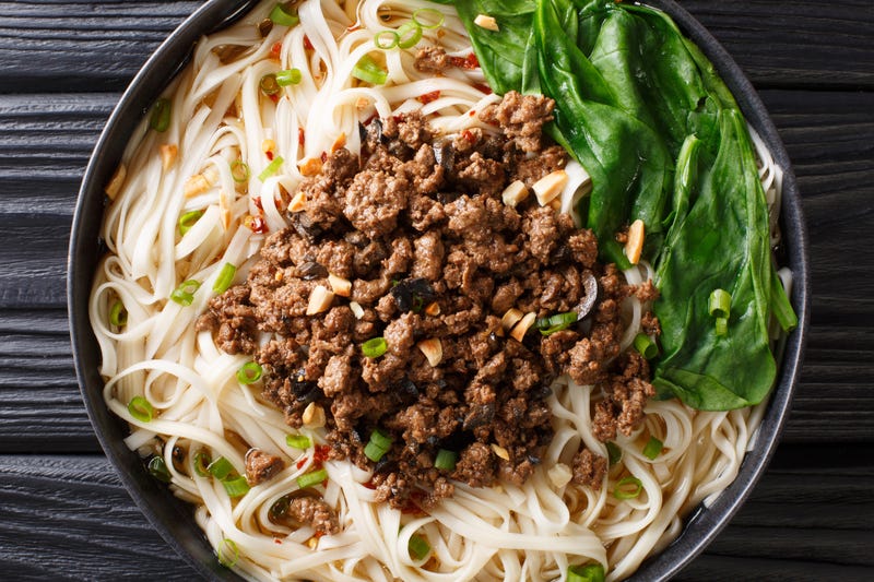 File Photo: Dan Dan Noodles - Savory and spicy Sichuan noodles served with ground meat closeup on the plate on the table.