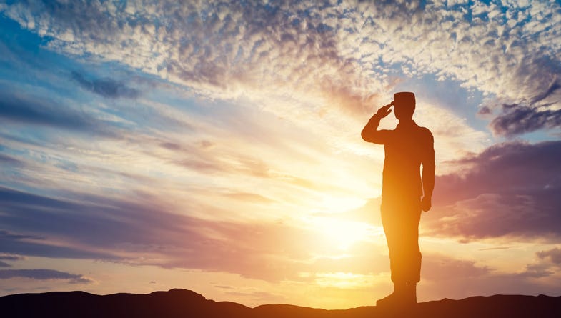 Soldier saluting at sunset. 
