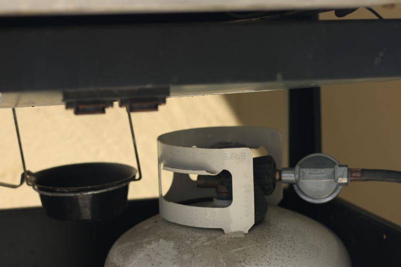 Propane tank attached to a grill.