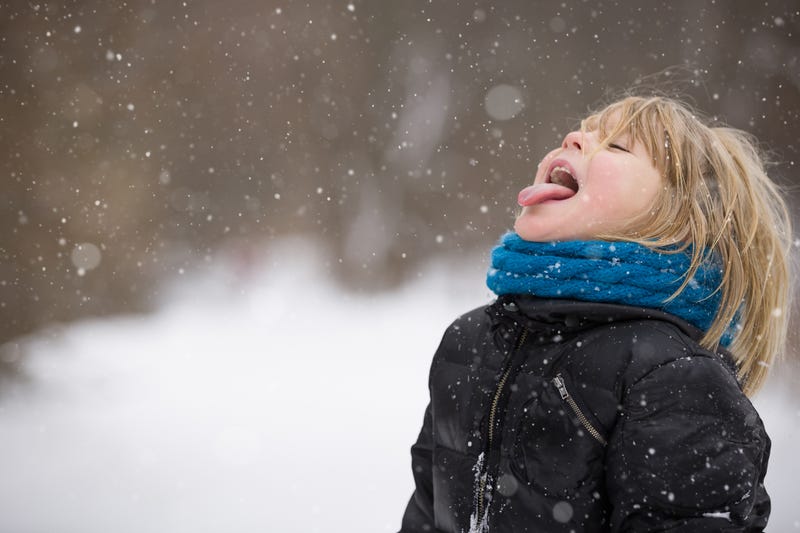 Kid catching snowflakes on his tongue