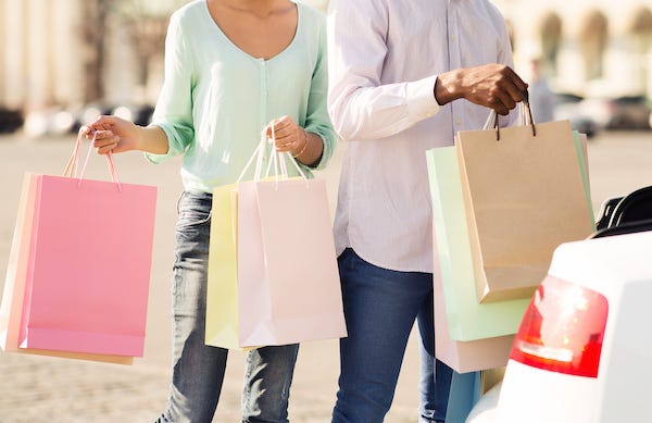 Young couple putting shopping bags in car