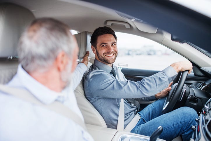 Father and son sitting in car, driving and talking