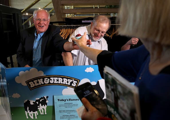 Ben & Jerry's co-founders Ben Cohen (L) and Jerry Greenfield (R) serve ice cream following a press conference announcing a new flavor, Justice Remix'd, September 03, 2019 in Washington, DC. Ben & Jerry's launched the new flavor in conjunction with the civil rights organization, Advancement Project, to "spotlight structural racism in a broken criminal legal system". (Photo by Win McNamee/Getty Images)
